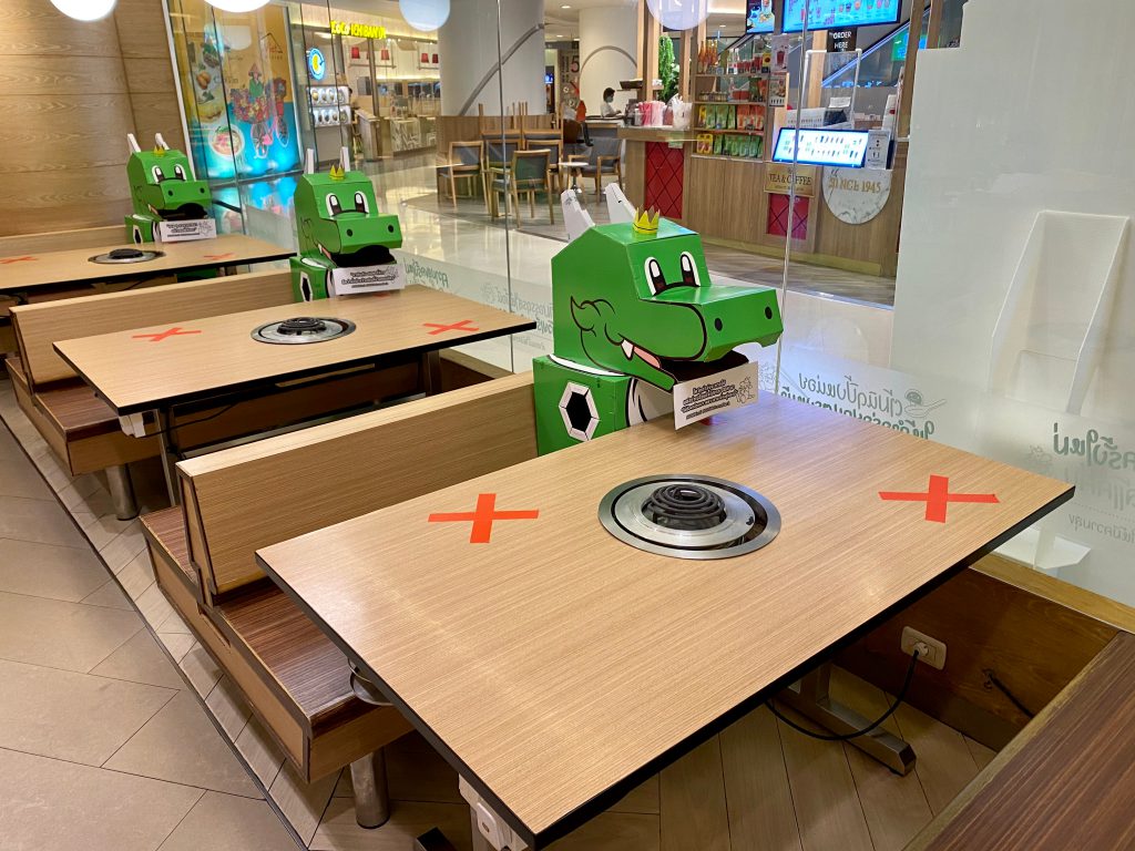 Bangkok, Thailand-May 20,2020: A restaurant in Thailand use its mascot green dragon to accompany guests who come to dine in isolated tables amid COVID-19 pandemic crisis.